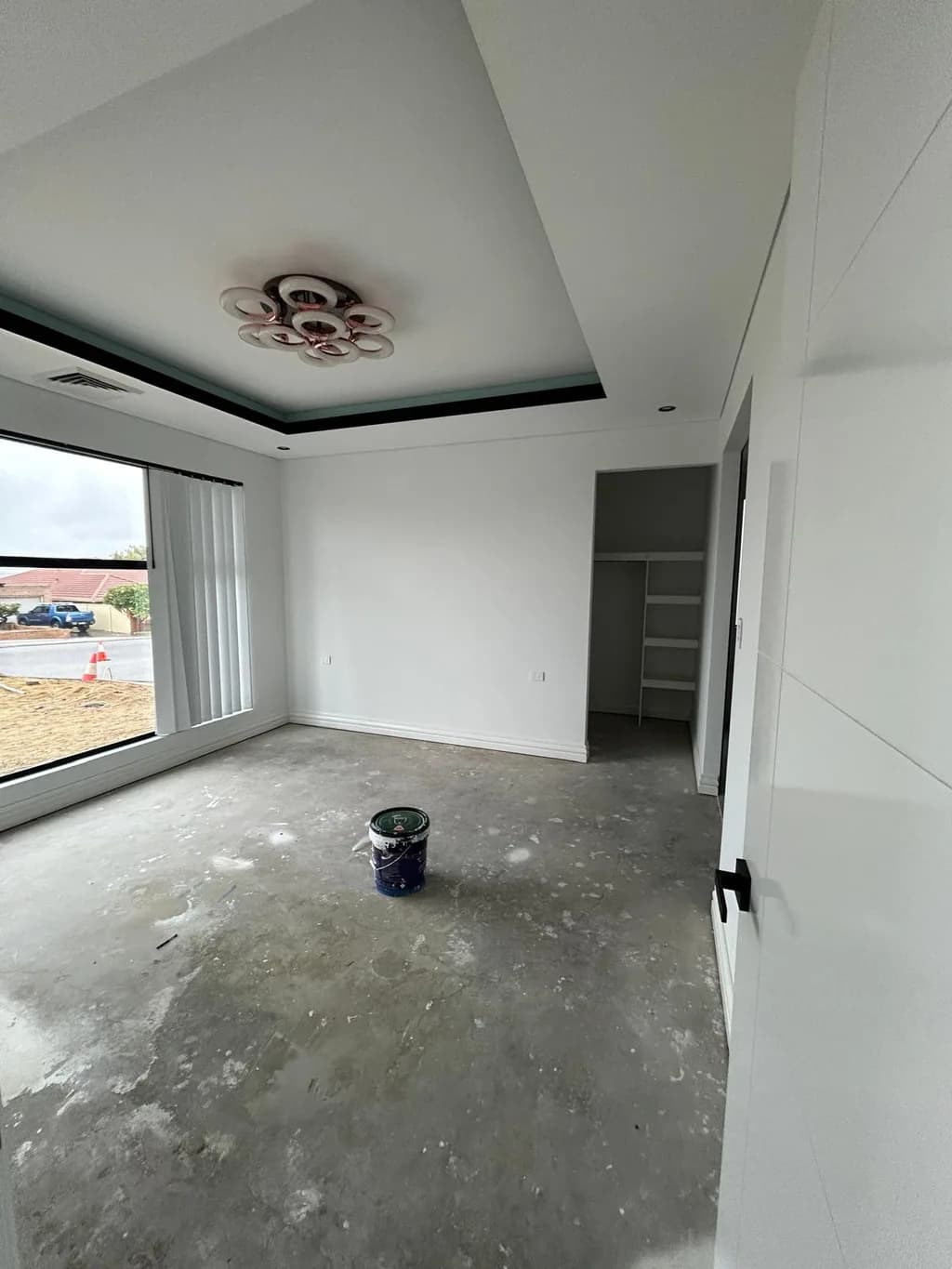 A bedroom painted out before floor coverings, walls and coffered ceiling finished