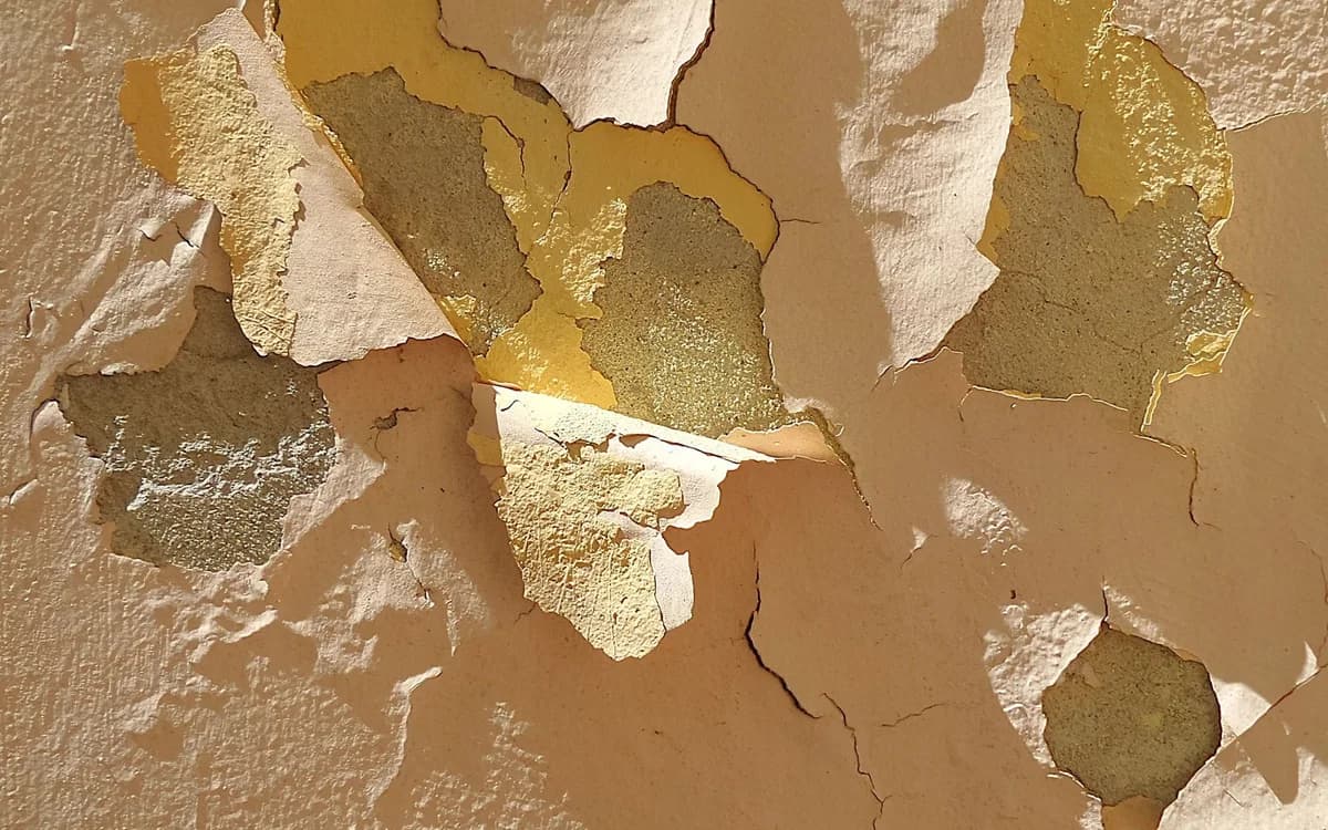 Weathered paint breaking down on an old exterior wall