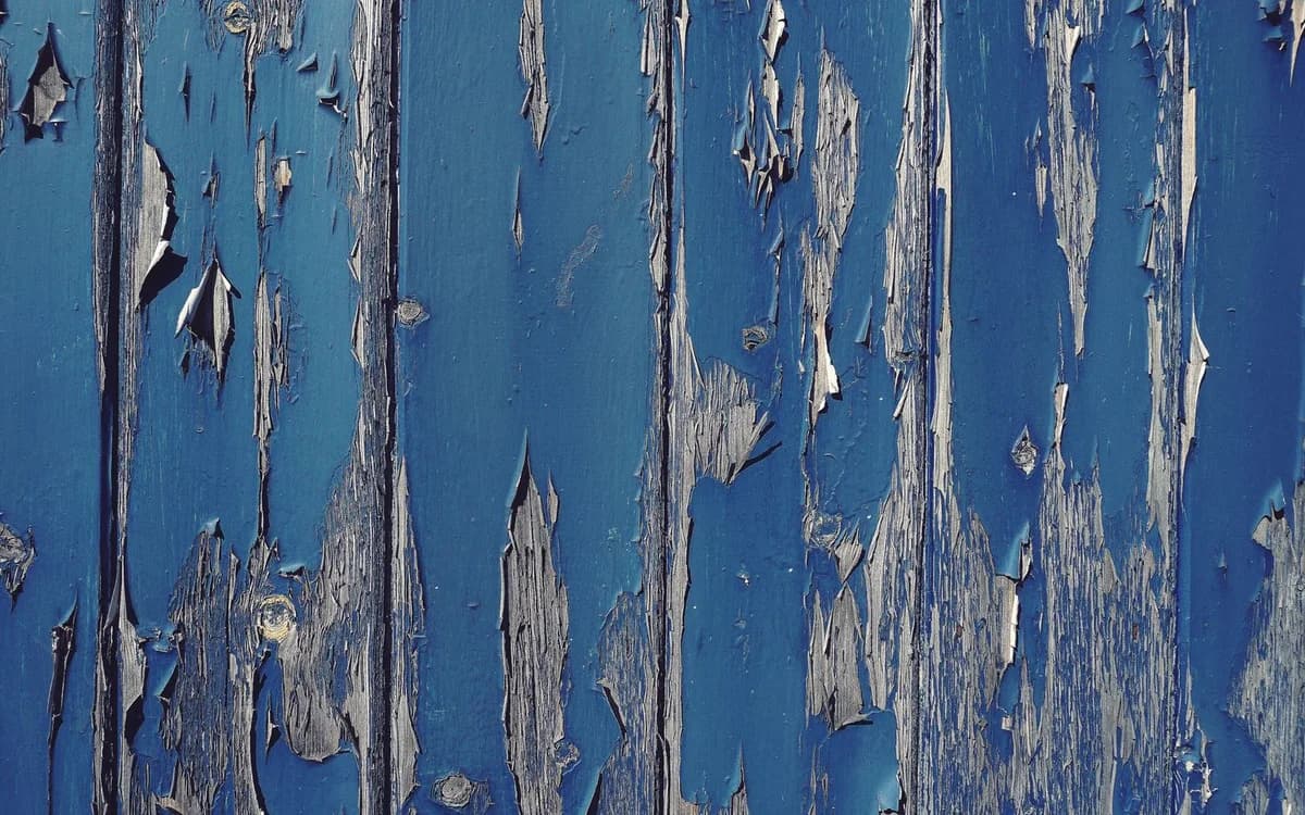 Cracked paint lifting from a weathered wall