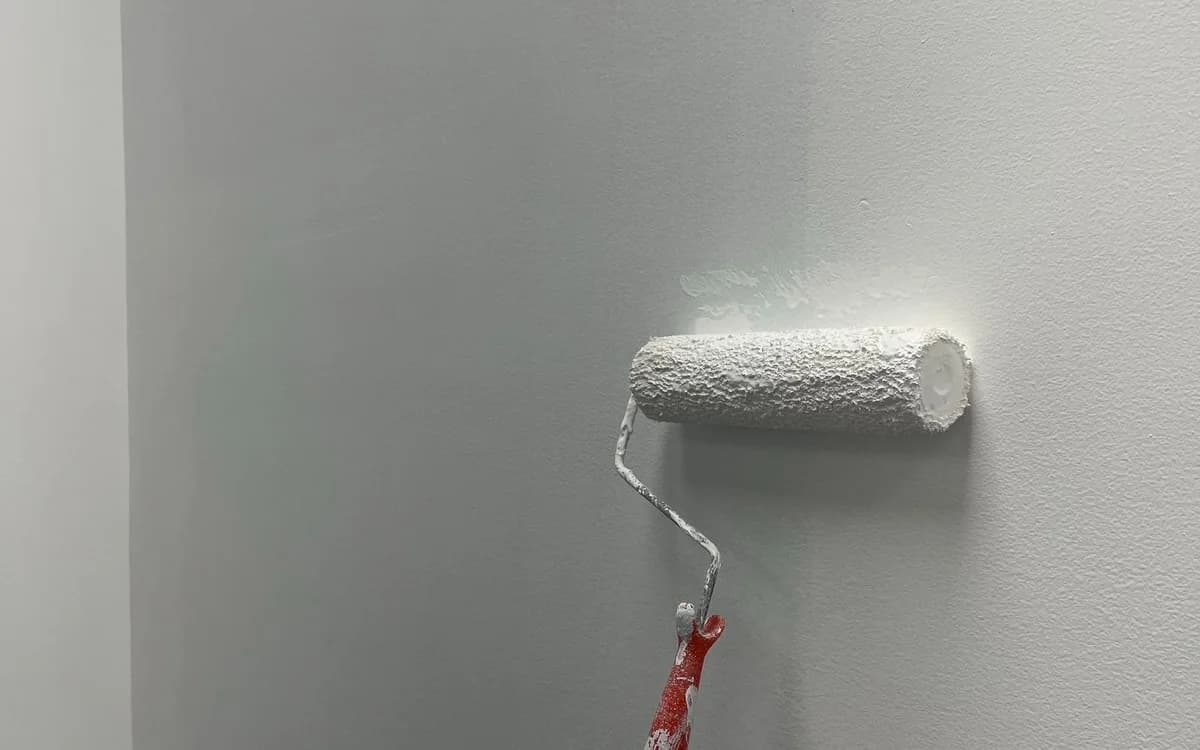 White paint being rolled onto an interior wall