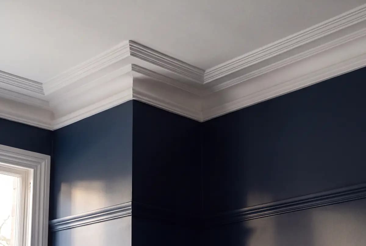 A painted interior corner showing wall, cornice and skirting