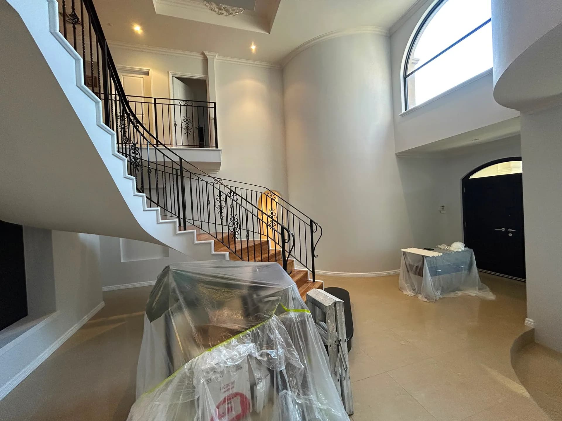 A finished double-height entry and curved stair on a CREST job