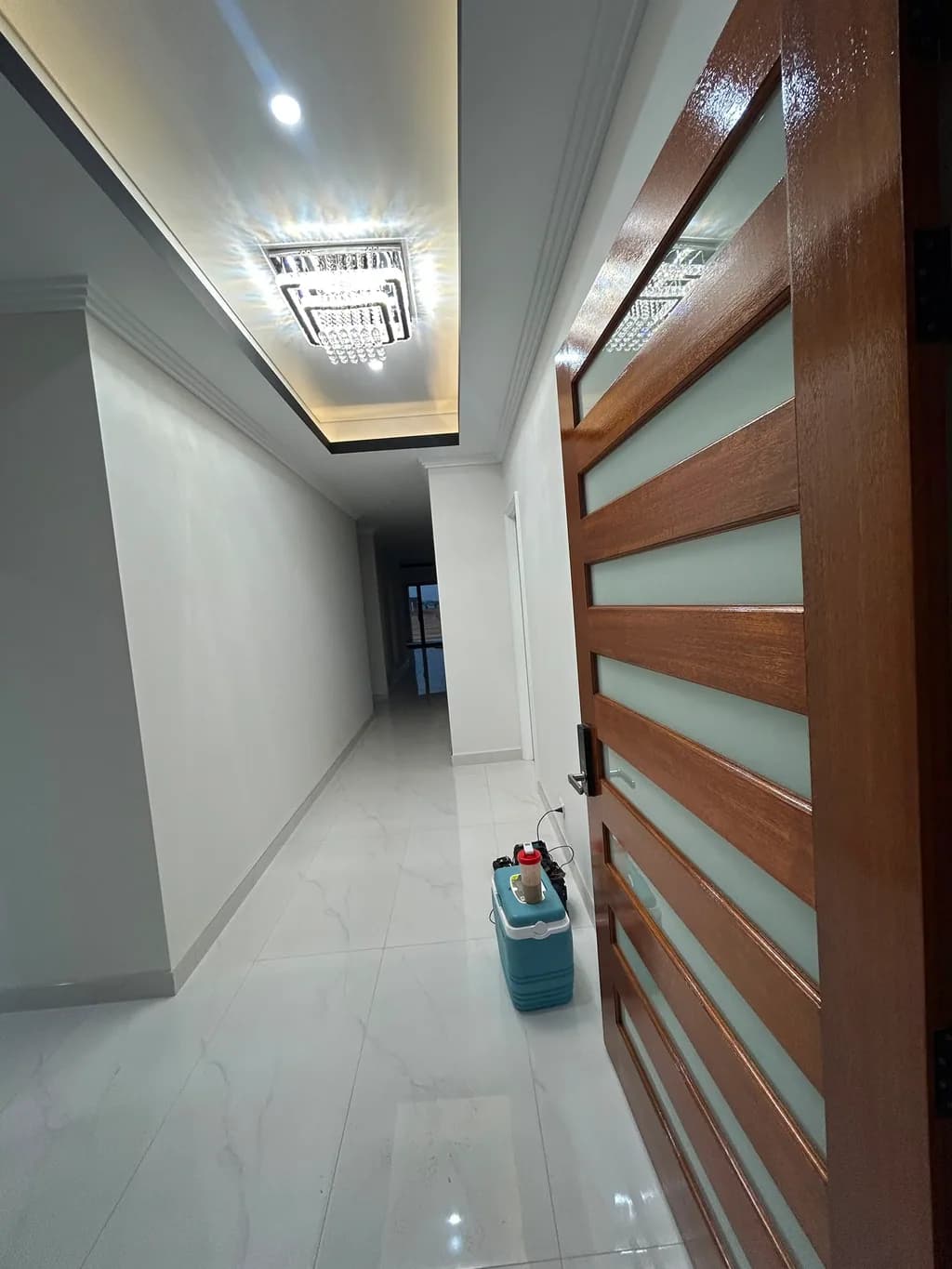 A finished hallway on a CREST job — walls and cornice cut in around a stained timber entry door