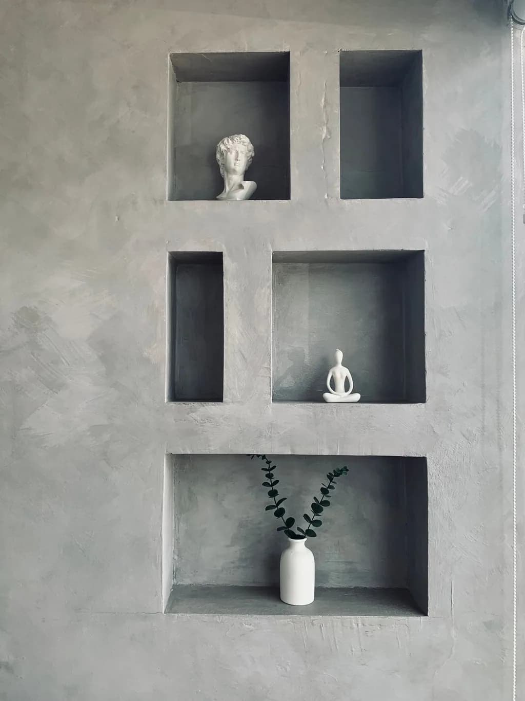 A polished venetian plaster wall with recessed display niches
