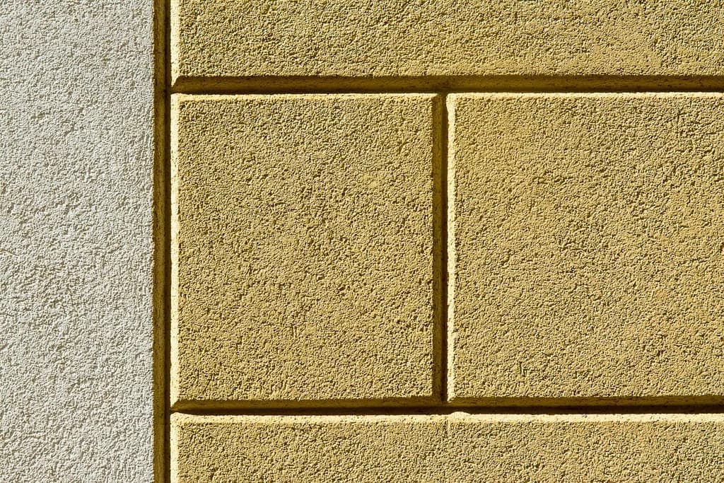 A coarse texture-coated render wall finished in deep yellow