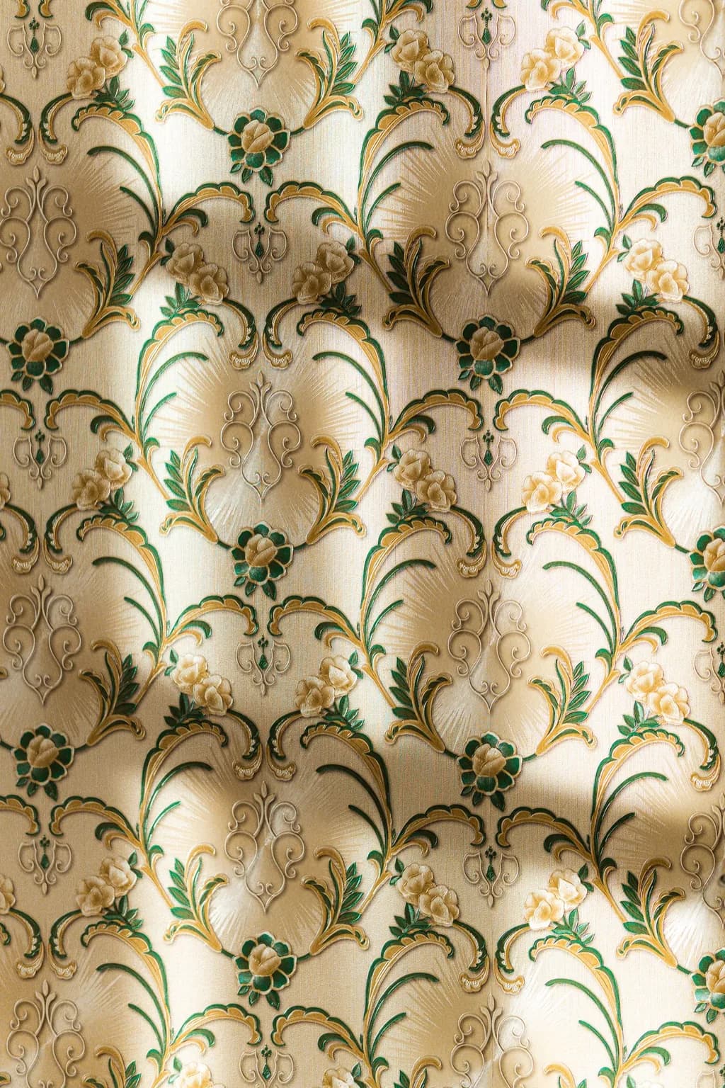 A gold and green damask wallpaper, hung flat and pattern-matched