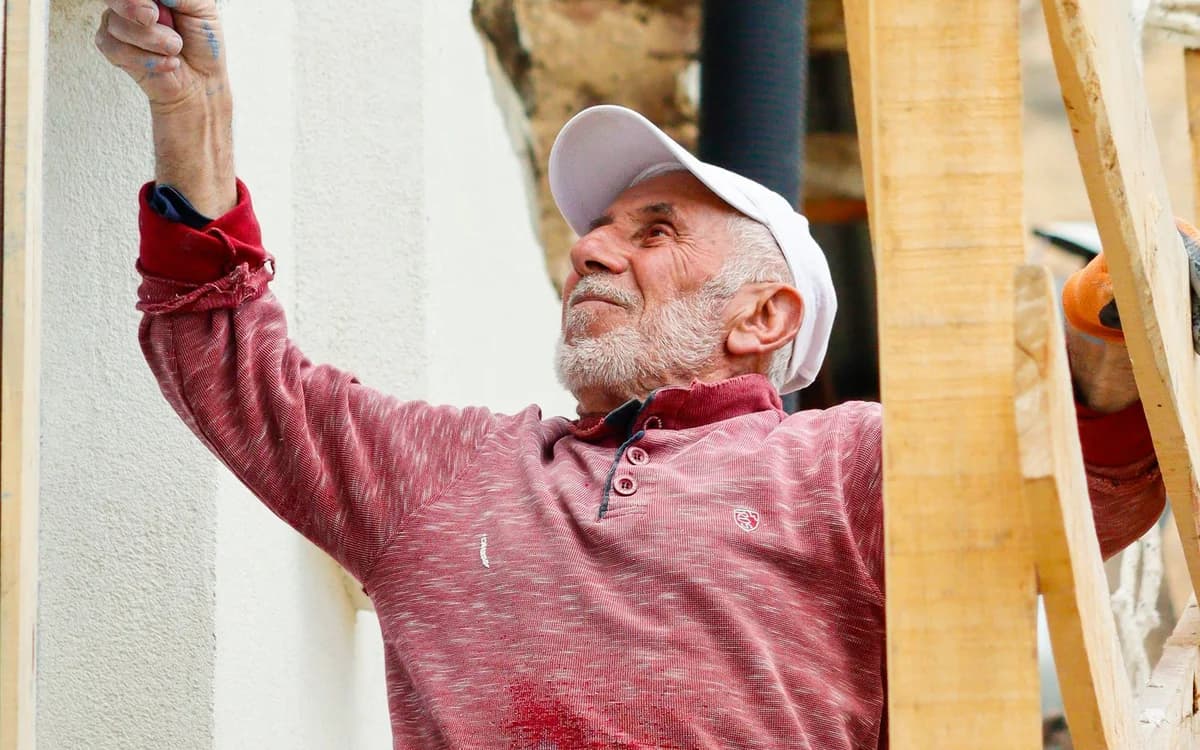 A painter working on an exterior wall from scaffolding