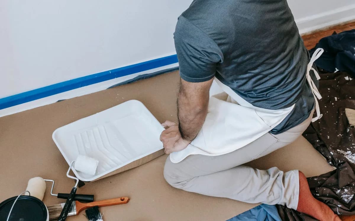 A painter rolling a wall during an interior repaint